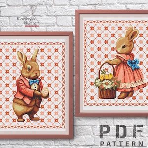 Peut inclure: Deux motifs de point de croix représentant des lapins. Un lapin porte un costume et tient un œuf. L'autre lapin porte une robe rose et tient un panier de poussins.