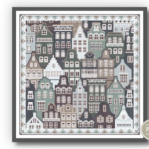May include: A cross-stitch pattern featuring a colorful cityscape with a variety of houses and buildings. The pattern is framed in a gray frame with a white border.