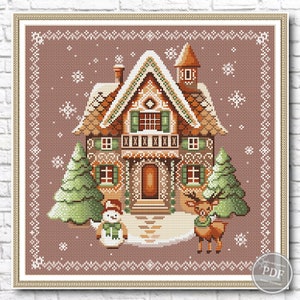 Christmas-themed cross stitch pattern depicting a gingerbread house adorned with white frosting and candy canes, flanked by trees, snowman, and reindeer, set against a blue background with snowflakes.