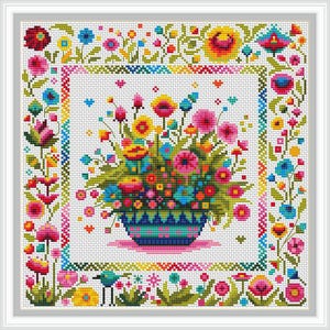 May include: A colorful cross-stitch pattern featuring a bouquet of flowers in a blue and white patterned vase. The flowers are pink, red, yellow, orange, and blue. The background is white with a colorful border.