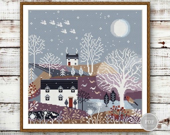May include: Cross stitch pattern featuring a wintery scene with two houses, a full moon, birds flying, and a robin perched on a branch. The houses are white with black trim and red doors. The scene is set against a blue sky with white snow.