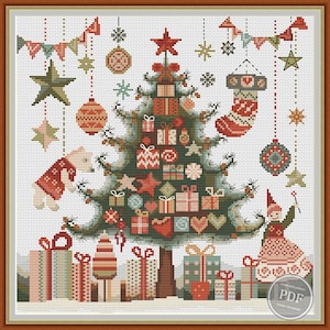 May include: A cross-stitch pattern featuring a Christmas tree decorated with presents, ornaments, and stars. A small elf is standing next to the tree, holding a star. The pattern is framed in a brown wooden frame.