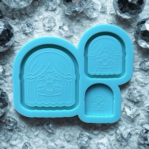 May include: A light blue silicone mould featuring a cartoon character design. The mould has three sections, each with a different size of the same design. The design includes a character with long hair, a crystal ball, and candles.