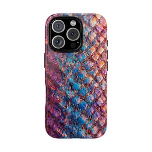 May include: A smartphone case with a colorful, textured design. The case features a pattern of overlapping scales in shades of blue, purple, orange, and pink. The phone case has a camera module with three lenses and a flash.
