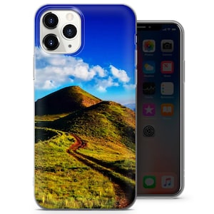 以下が含まれることがあります： 青い空と白い雲、緑の丘陵地帯を蛇行する土の道を写した風景写真がプリントされたスマホケースです。