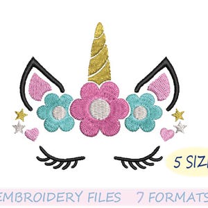 Peut inclure: Un visage de licorne brod&eacute; avec une corne dor&eacute;e, des cils noirs et des fleurs roses et bleues. Le motif comprend le texte "5 SIZES" et "EMBROIDERY FILES 7 FORMATS". Le motif est sur fond blanc.