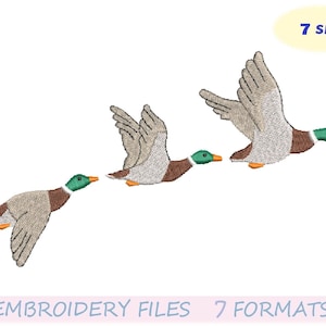May include: An embroidery design featuring three ducks in flight. The ducks have brown, gray, green, and orange details. The text "7 sizes" is in a yellow oval. The text "EMBROIDERY FILES 7 FORMATS" is at the bottom.