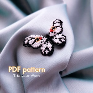 Könnte beinhalten: Ein schwarz-weißer Perlen-Schmetterling mit roten Akzenten. Der Schmetterling befindet sich auf einem hellblauen Stoffhintergrund. Der Text "PDF pattern Triangular Weave" befindet sich unter dem Schmetterling.