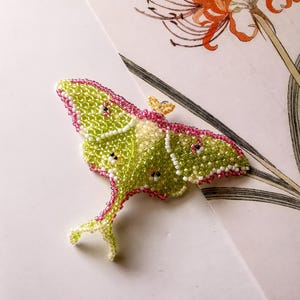 Luna moth seed bead brooch on floral paper — DIY beadweaving tutorial PDF