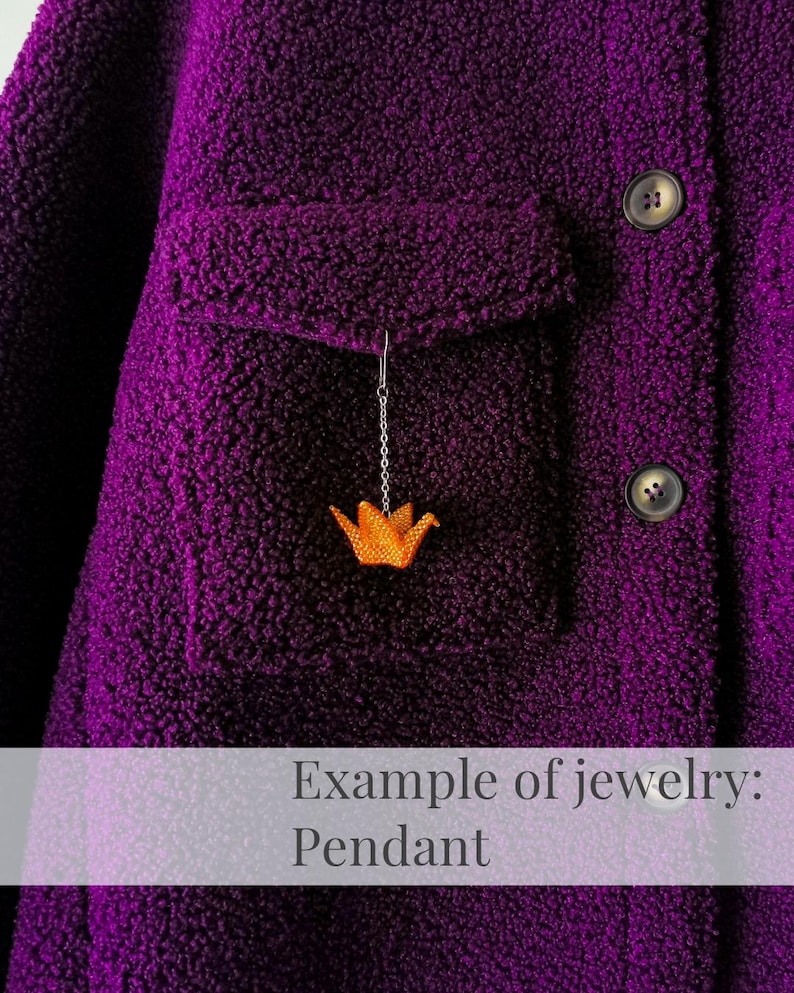 May include: A purple fleece jacket with a small orange origami bird pendant hanging from the pocket.