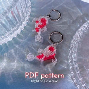 Könnte beinhalten: Zwei Perlenfisch-Schlüsselanhänger mit roten und weißen Perlen. Die Schlüsselanhänger hängen an silbernen Schlüsselringen. Der Text "PDF pattern Right Angle Weave" befindet sich am unteren Rand des Bildes.