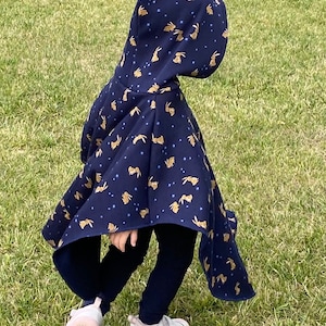 Car seat/stroller poncho with hood. Essential for the safety of your baby and toddler. Cozy alpine fleece with bunny motif.