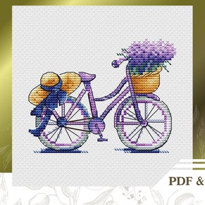 May include: A purple bicycle with a basket full of lavender flowers and a straw hat tied to the handlebars.
