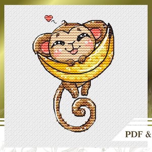 May include: Cross-stitch design featuring a smiling monkey embracing a banana. The monkey is brown with pink cheeks and ears, and a small red heart floats above. The banana is yellow with brown shading. Text at the bottom reads "PDF & Saga".
