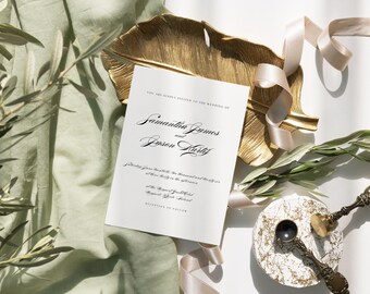 May include: A white wedding invitation with black calligraphy text. The text reads "You are kindly invited to the wedding of Samantha James and  Josen Kurty". The invitation is on a gold leaf-shaped tray with a light green fabric and a light pink ribbon in the background.