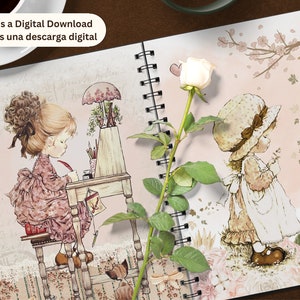 K&ouml;nnte beinhalten: Ein rosa-wei&szlig;es Spiralnotizbuch mit floralem Design und zwei Illustrationen von M&auml;dchen. Der Text "This is a Digital Download Esta es una descarga digital" ist auf dem Cover gedruckt.