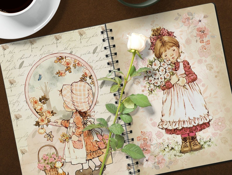 K&ouml;nnte beinhalten: Ein Notizbuch im Vintage-Stil mit floralem Design und zwei Illustrationen von M&auml;dchen. Ein M&auml;dchen h&auml;lt einen Strau&szlig; wei&szlig;er Rosen und das andere schaut auf einen Vogel in einem runden Rahmen. Eine wei&szlig;e Rose mit gr&uuml;nen Bl&auml;ttern befindet sich auf der linken Seite des Notizbuchs.