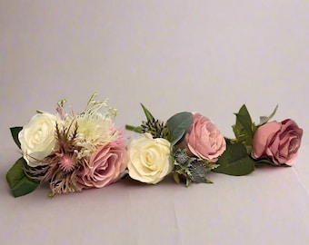 Op de afbeelding: Drie kunstbloemenarrangementen met roze en witte rozen, groen en andere bloemmotieven.
