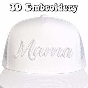 May include: White trucker cap with the word "Mama" embroidered in a cursive font. The cap has a mesh back and a flat peak. The text "3D Embroidery" is above the cap.