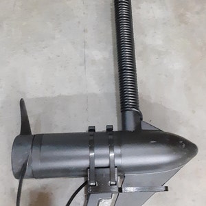 May include: A black trolling motor with a propeller, a ribbed shaft, and a mounting bracket. The motor is designed for use in boats and other watercraft. The propeller has two blades.
