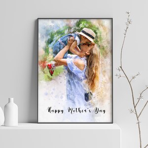 May include: A watercolor painting of a mother and child. The mother is holding the child in the air and they are kissing. The child is wearing a blue shirt and a straw hat. The mother is wearing a blue dress. The background is a watercolor wash of green and blue. The text "Happy Mother's Day" is written at the bottom of the painting.