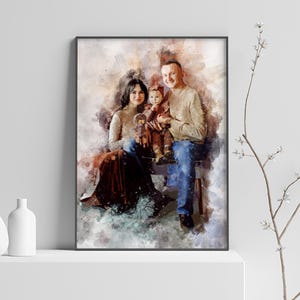 May include: A watercolor painting of a family of three. A man, woman, and child are sitting together. The man is wearing a beige sweater and blue jeans. The woman is wearing a brown dress and the child is wearing a pink dress. The painting has a soft, dreamy feel.