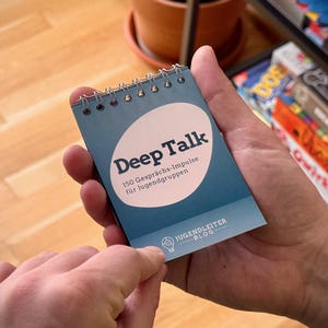 Könnte beinhalten: Ein blaues spiralgebundenes Notizbuch mit dem Titel "Deep Talk" und dem Text "150 Gesprächs-Impulse für Jugendgruppen" und "JUGENDLEITER BLOG".