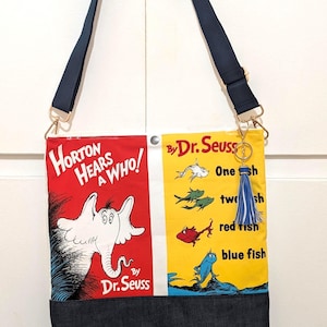 May include: A rectangular shoulder bag featuring Dr. Seuss book cover graphics. The left side is red with Horton Hears a Who, and the right side is yellow with One Fish Two Fish Red Fish Blue Fish. It has a dark denim base, strap, and a blue tassel.
