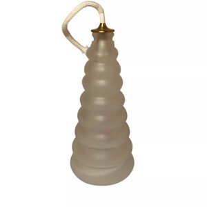 May include: A frosted glass lamp pull with a gold-coloured metal cap and a white rope. The lamp pull has a ridged, cone-like shape. The background is plain white.