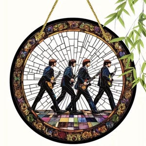 May include: A round wall hanging in the style of a stained glass window, featuring a colourful mosaic design with four figures in silhouette playing guitars. The figures are walking in a line, and the background is a colourful mosaic of squares and circles.