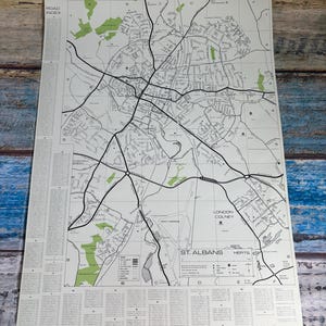 May include: A printed map of St. Albans, Herts, featuring a detailed street layout with black lines on a white background, green park areas, a road index on the left, a legend at the bottom, and grid coordinates labelled A through F and 1 through 8.