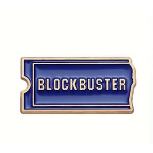 May include: A gold-coloured pin with a blue background and the word "BLOCKBUSTER" in white lettering.
