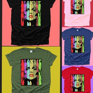 May include: Five t-shirts in different colours featuring a graphic print of Blondie singer Debbie Harry's face against a colourful striped background. The text "Blondie" is printed above the graphic.