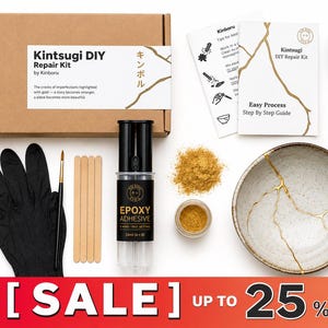 May include: A Kintsugi DIY repair kit by Kinboru including a cardboard box, black gloves, a paintbrush, wooden stir sticks, epoxy adhesive, gold powder, and several ceramic bowls and fragments featuring gold-filled cracks for pottery restoration.