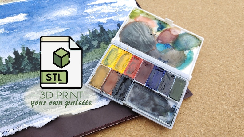 Pu&ograve; includere: Un dipinto ad acquerello di un lago e alberi con un'icona bianca e verde di un file etichettato "STL" e il testo "3D PRINT - your own palette". Una tavolozza di acquerello in plastica bianca con 12 pozzetti di vernice &egrave; aperta e parzialmente riempita di vernice.