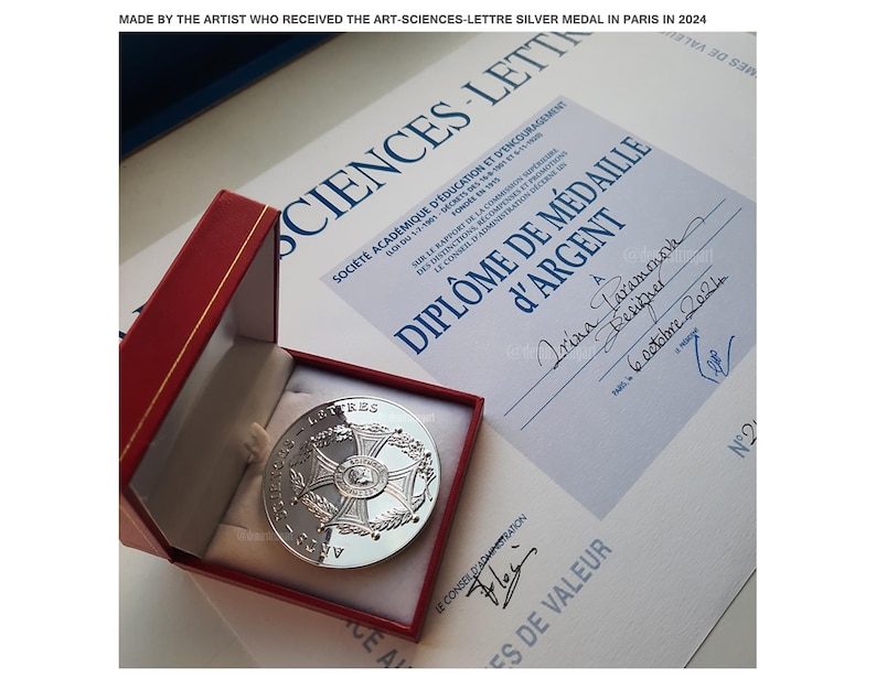 May include: A silver medal in a red box with a certificate that reads "Diplome de Medaille d'Argent" and "A Irina Laramonosn Designer 6 October 2024".