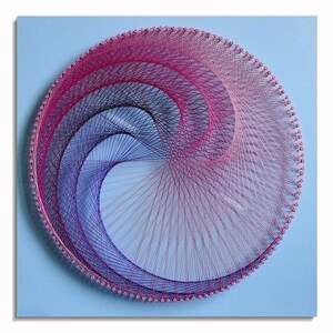May include: A circular string art piece with a blue background. The string art is made with pink and purple thread, creating a swirling pattern.