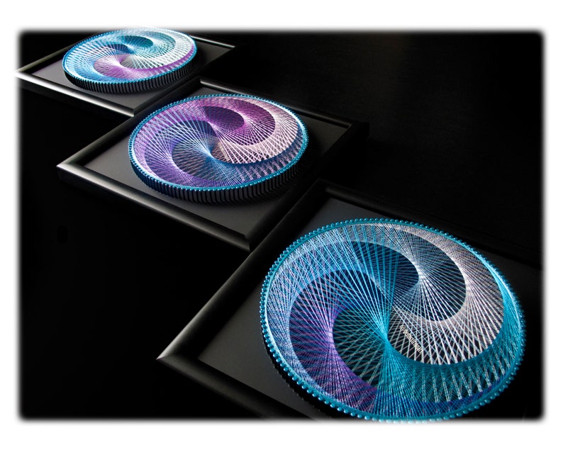 May include: Three framed circular string art pieces with a swirling design in shades of blue, purple, and white.