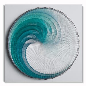 May include: A circular string art piece featuring a wave design. The artwork uses shades of teal and white thread, creating a gradient effect. The piece is mounted on a square, white background. The artist's name, @demistringart, is visible.