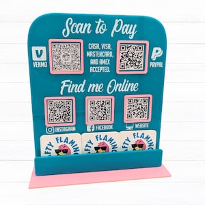 May include: A teal acrylic point-of-sale display with the text "Scan to Pay" and "Find me Online." It features QR codes for Venmo, PayPal, Instagram, Facebook, and a website. The display also accepts Cash, Visa, Mastercard, and Amex.