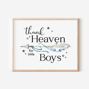 Puede incluir: Impresión enmarcada con el texto "thank Heaven for little Boys" en escritura negra. Una flecha de acuarela con acentos azules y grises está centrada, rodeada de estrellas azules y grises. El marco es de madera clara.