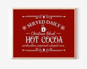 May include: A red sign with white text that reads "Served Daily - Christmas Blend - Hot Cocoa - marshmallows, peppermint, whipped cream". The sign has a decorative border and a small image of a cup of cocoa.