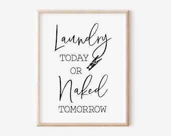 May include: Black and white typography print with the text "Laundry Today or Naked Tomorrow" in a cursive font. The print is framed in a light wood frame.