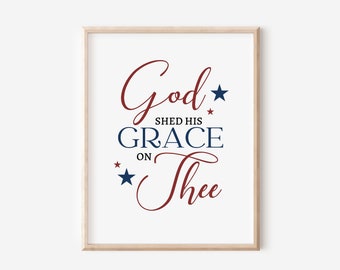 May include: A printable wall art design with the text "God Shed His Grace On Thee" in red and blue lettering with stars.