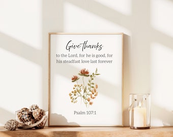 May include: A framed print with a watercolor illustration of flowers and the text "Give thanks to the Lord, for he is good, for his steadfast love last forever. Psalm 107:1".