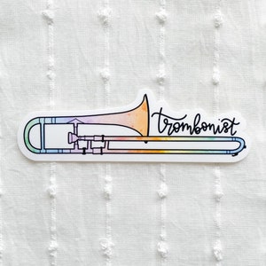 May include: A rainbow-coloured trombone sticker with the word "trombonist" written in black cursive.