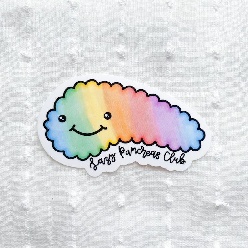 May include: A sticker featuring a smiling, rainbow-colored pancreas with a scalloped edge. The sticker has the text "Lazy Pancreas Club" in a handwritten font. The design is on a white background.