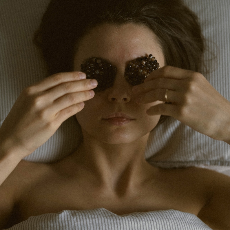 K&ouml;nnte beinhalten: Eine Person liegt mit geschlossenen Augen und tr&auml;gt schwarze Augen-Patches.