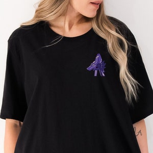 May include: A black oversized t-shirt with a purple wolf graphic on the front.