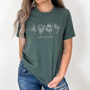 May include: A green t-shirt with a white outline of flowers and the word "Inazuma" printed on the front.